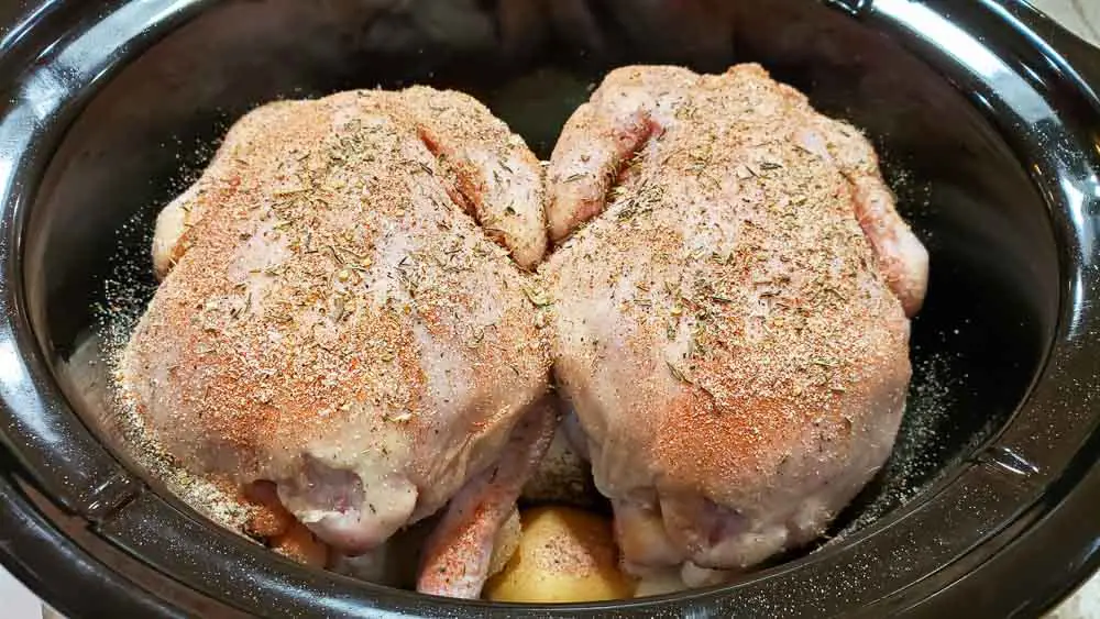 two Cornish hens added to slow cooker crock pot and sprinkled with seasonings