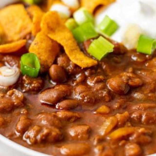 a bowl of chili topped with frito corn chips.