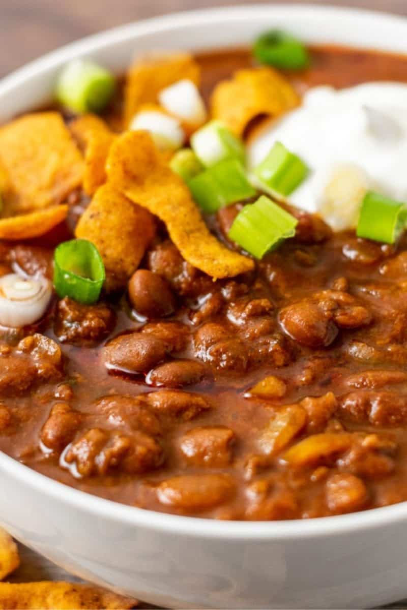 a bowl of chili topped with frito corn chips.