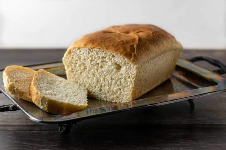 a loaf of bread with two end slices cut on a tray