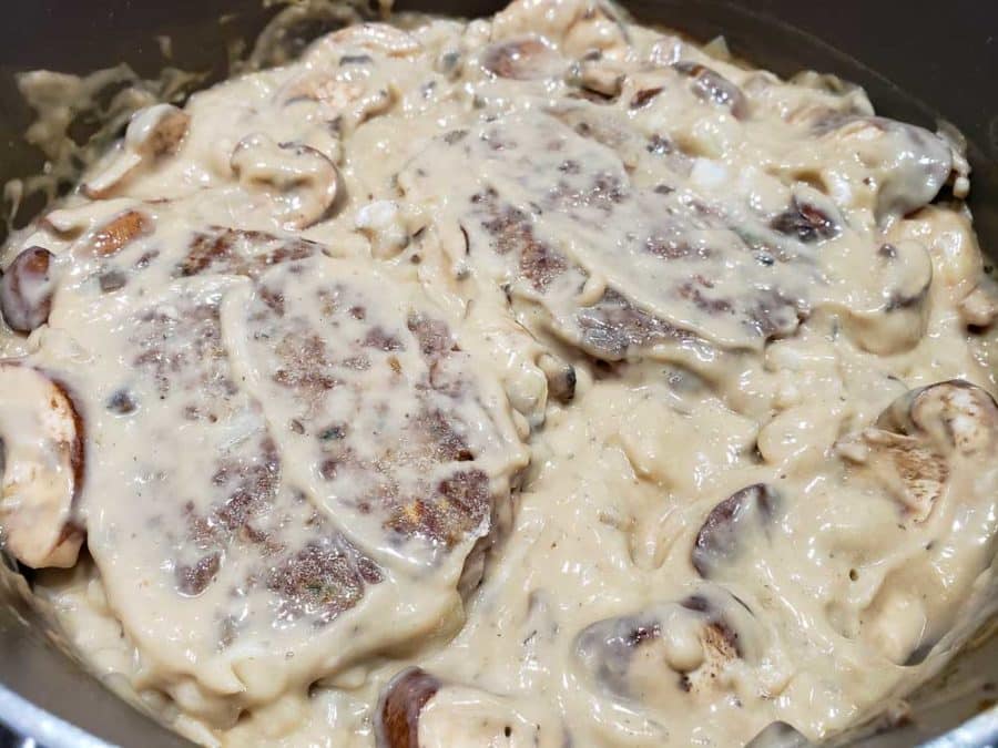 salisbury steak patties added to mushroom gravy in frying pan