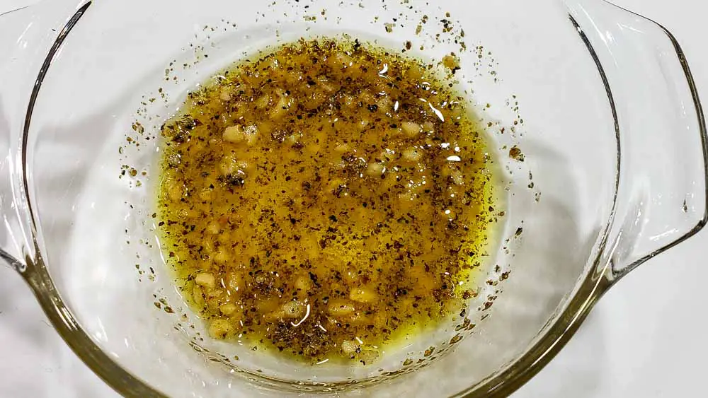 garlic, salt, olive oil, and lemon pepper seasoning mixed in a bowl