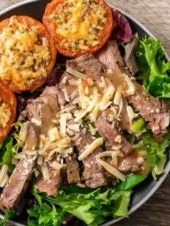 Strip Steak Salad with Broiled Parmesan Tomatoes on a plate.