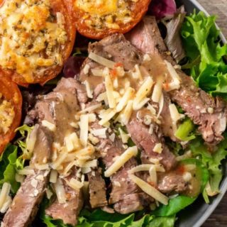 Strip Steak Salad with Broiled Parmesan Tomatoes on a plate.