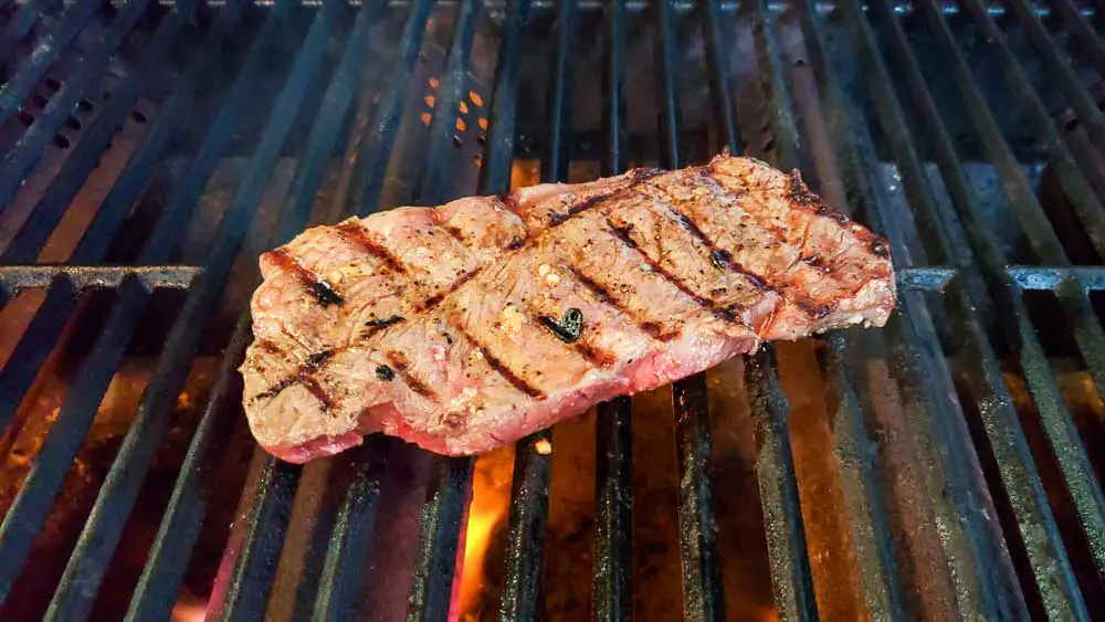 ribeye steak cooking on a grill