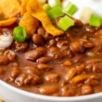 a bowl of chili topped with frito corn chips.