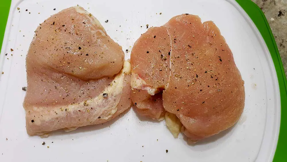 salt and pepper on two chicken filets.