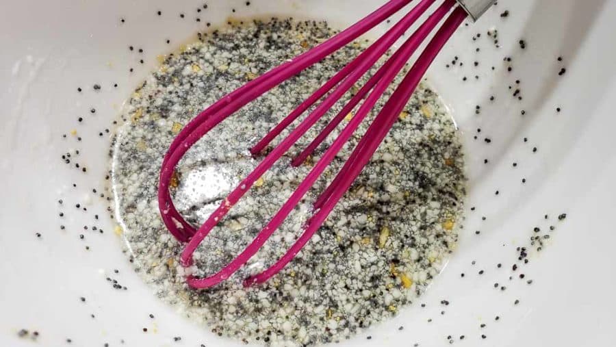 dried minced onion flakes, poppy seeds, salt, ground mustard, and mayonnaise added to dressing