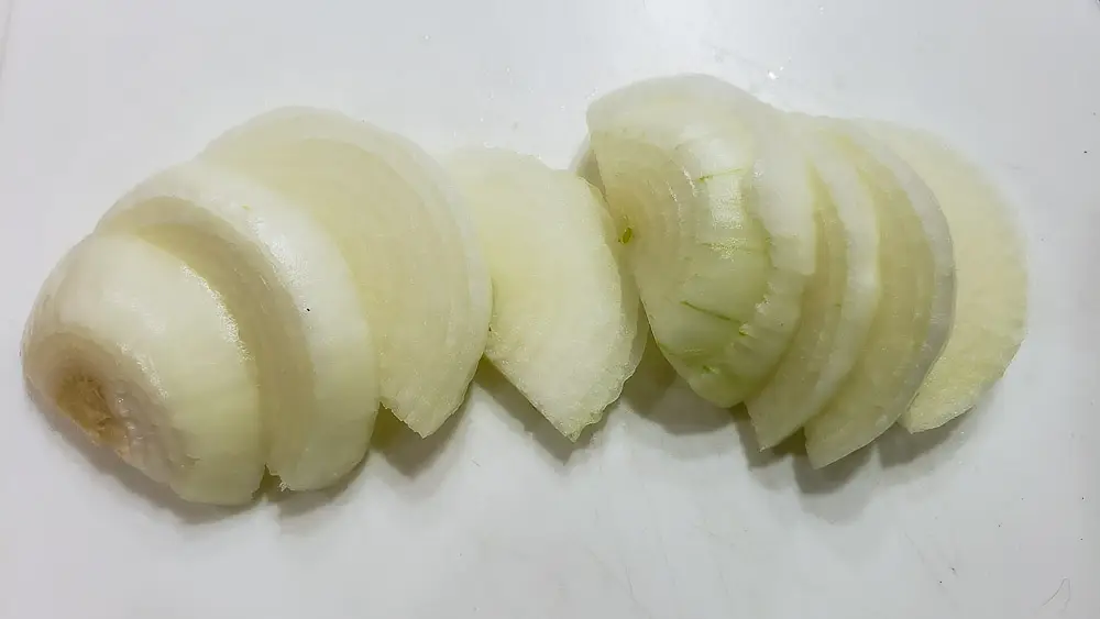 onion sliced on a cutting board.
