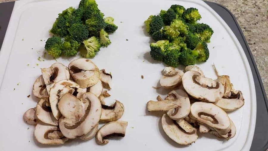 chopped broccoli and mushrooms on a cutting board