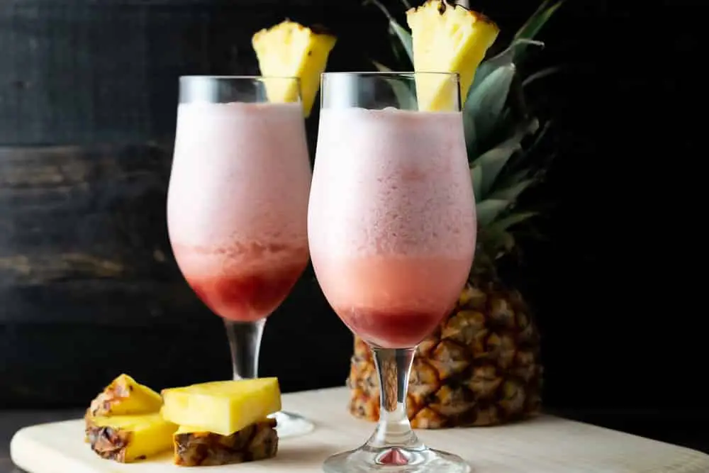2 Lava Flow Hawaiian drinks with pineapple garnish