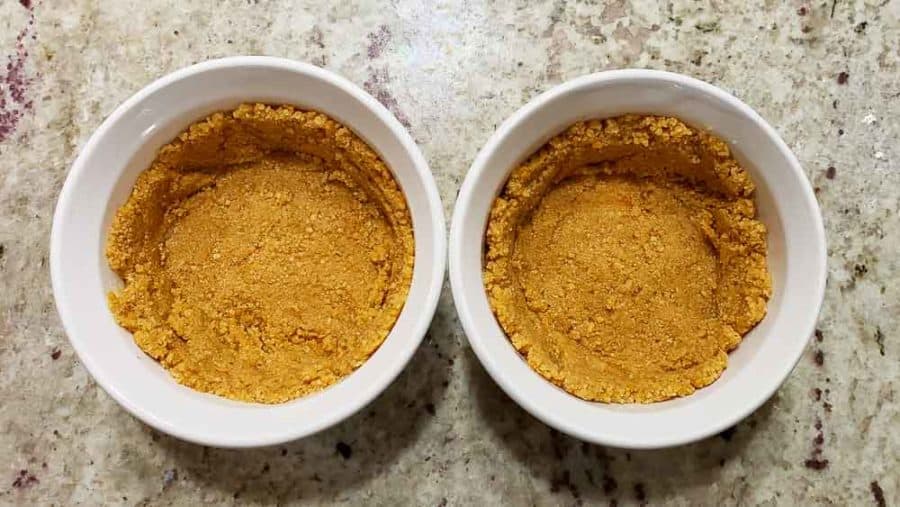 buttery graham crumbs pressin into two ramekins