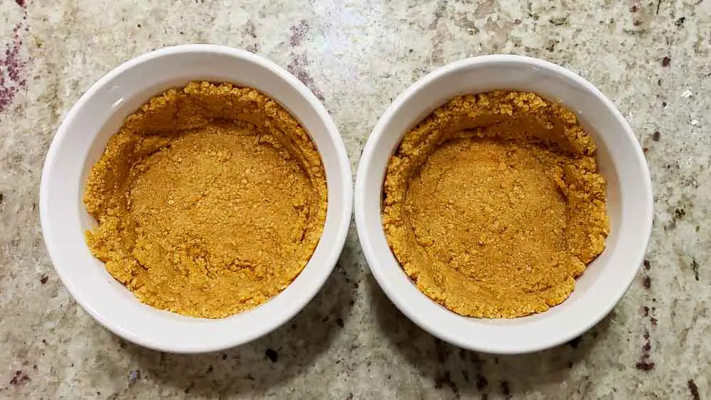 buttery graham crumbs pressed into two ramekins.
