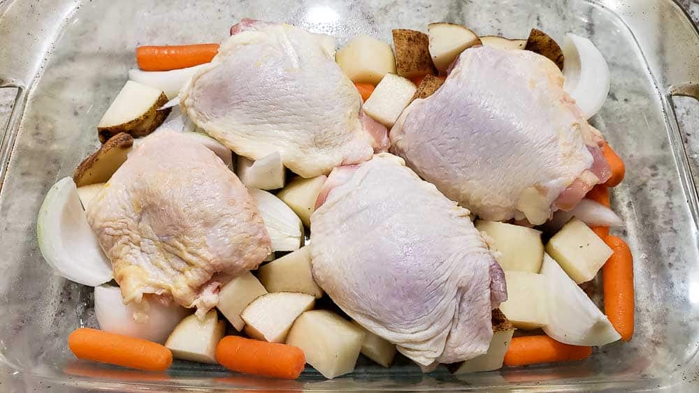 chicken thighs and vegetables in a baking dish