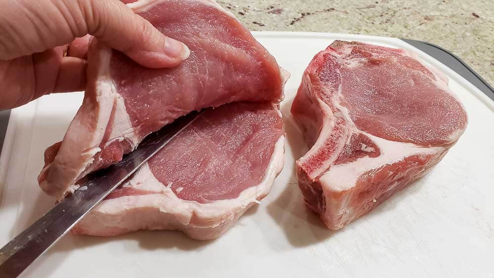 a knife slicing the pork chops open.