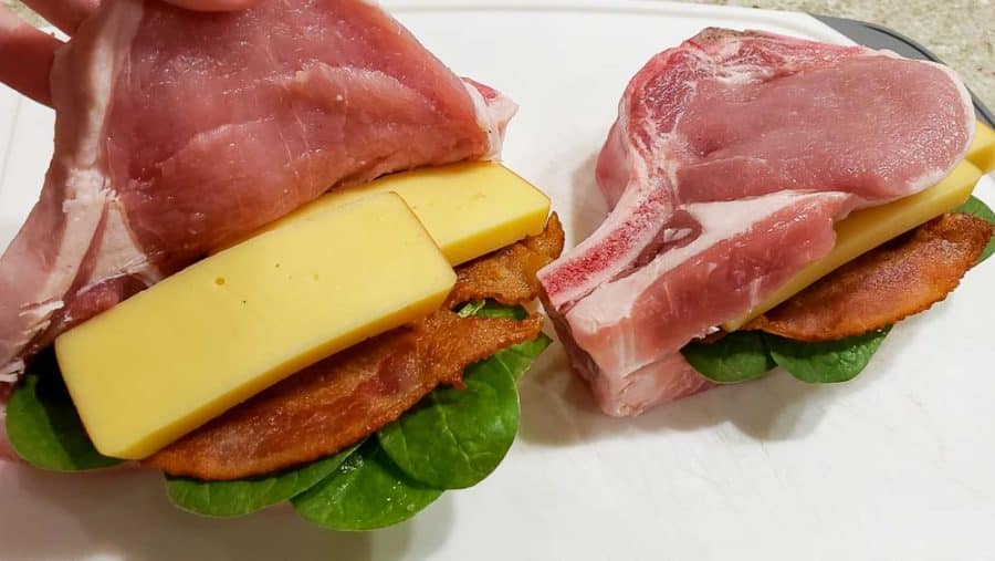 adding two slices of smoked gouda inside the pork chops