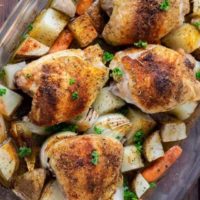 Baked Chicken Thighs with Potatoes and Carrots in a casserole dish.