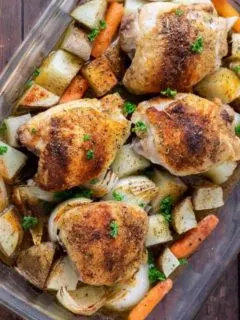 Baked Chicken Thighs with Potatoes and Carrots in a casserole dish.