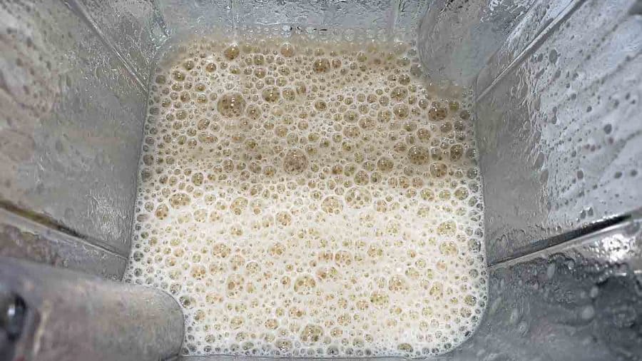 top down view inside blender with coffee, milk, and sugar blended together
