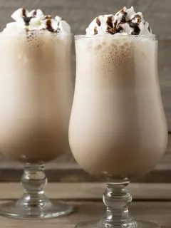 two Arby's Copycat Jamocha Shakes topped with whipped cream and chocolate drizzle