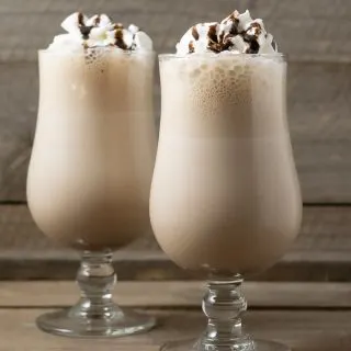 two Arby's Copycat Jamocha Shakes topped with whipped cream and chocolate drizzle