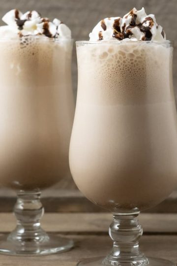 two Arby's Copycat Jamocha Shakes topped with whipped cream and chocolate drizzle