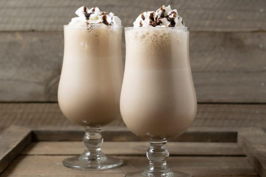 two Arby's Copycat Jamocha Shakes topped with whipped cream and chocolate drizzle
