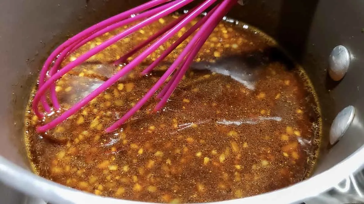 soy sauce mixture in a sauce pan with a whisk.