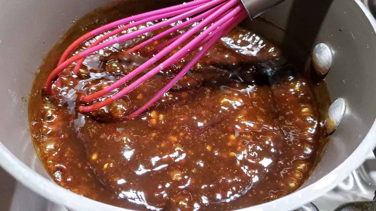 soy sauce mixture thickened with cornstarch in a sauce pan with a wisk.