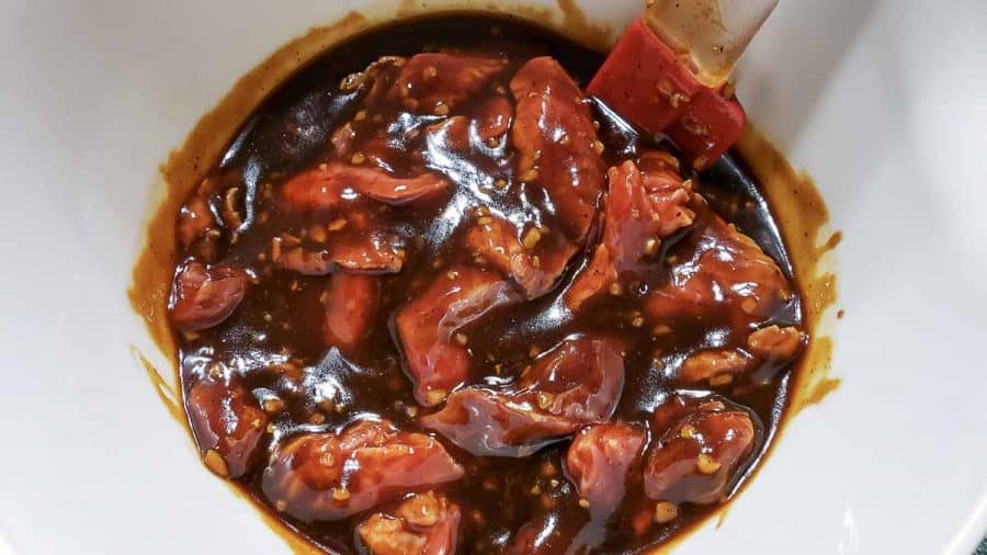 thin sliced beef mixed in a bowl with the soy sauce mixture