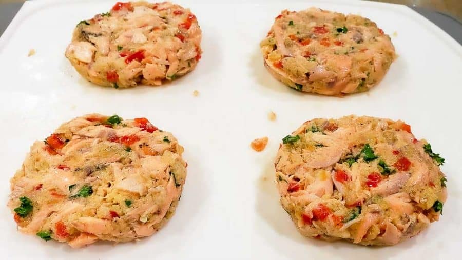 4 salmon patties formed on a cutting board