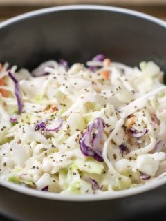 classic creamy coleslaw in a bowl with a fork on the side