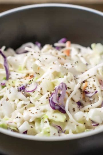 classic creamy coleslaw in a bowl with a fork on the side