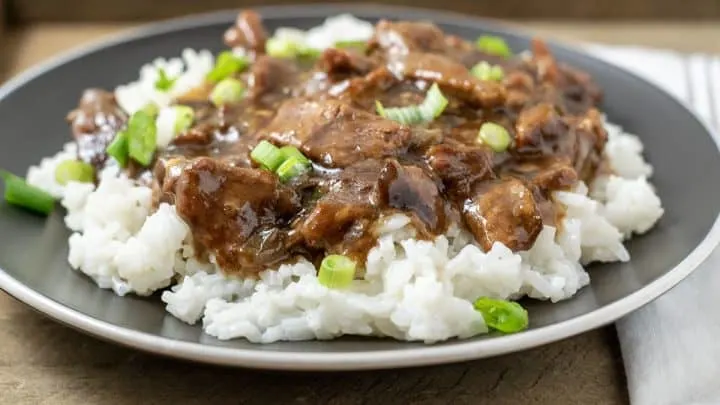 Crock Pot Mongolian Beef over rice on a plate.