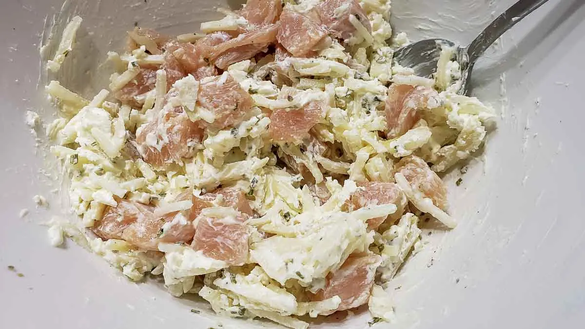 hashbrowns, chicken, garlic powder, onion powder, chives, cream cheese, salt and pepper mixed in a bowl.