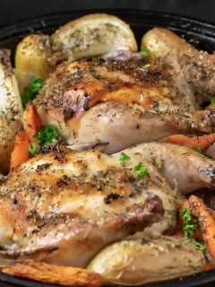 a cast iron skillet filled with Oven Roasted Cornish Hens and Veggies