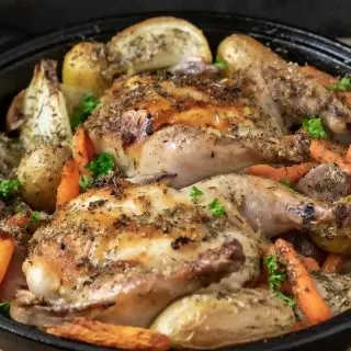 a cast iron skillet filled with Oven Roasted Cornish Hens and Veggies