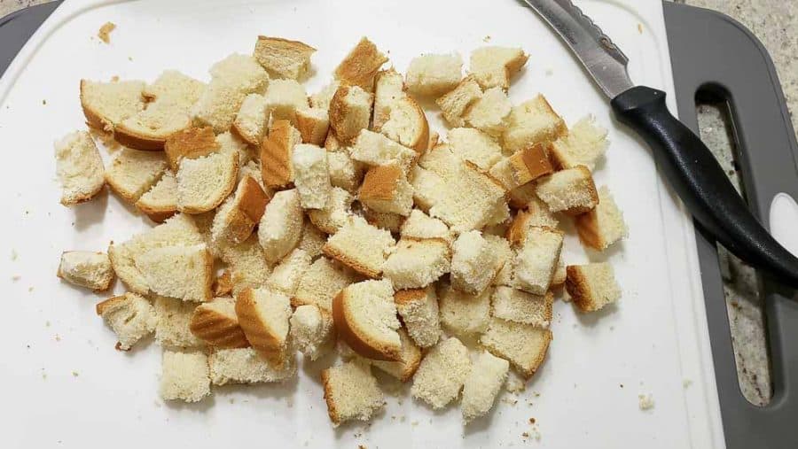 bread cut into cubes on a cutting board.