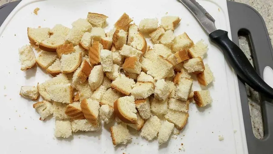 bread cut into cubes on a cutting board.