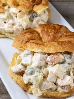 two chicken salad croissant sandwiches on a platter