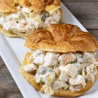 two chicken salad croissant sandwiches on a platter