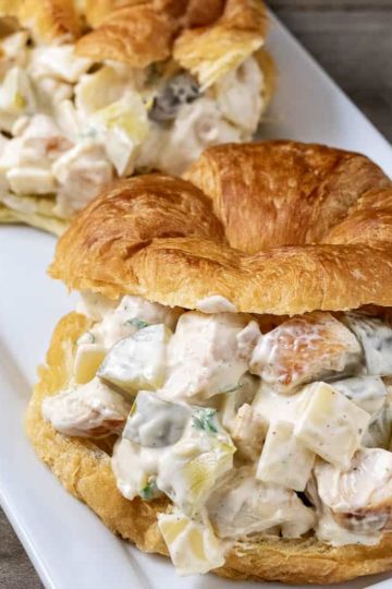 two chicken salad croissant sandwiches on a platter