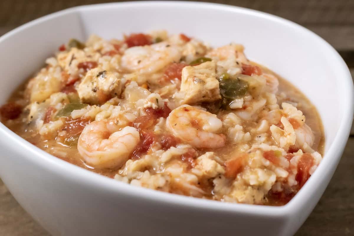 easy slow cooker jambalaya for two with chicken, shrimp, and rice served in a white dish.