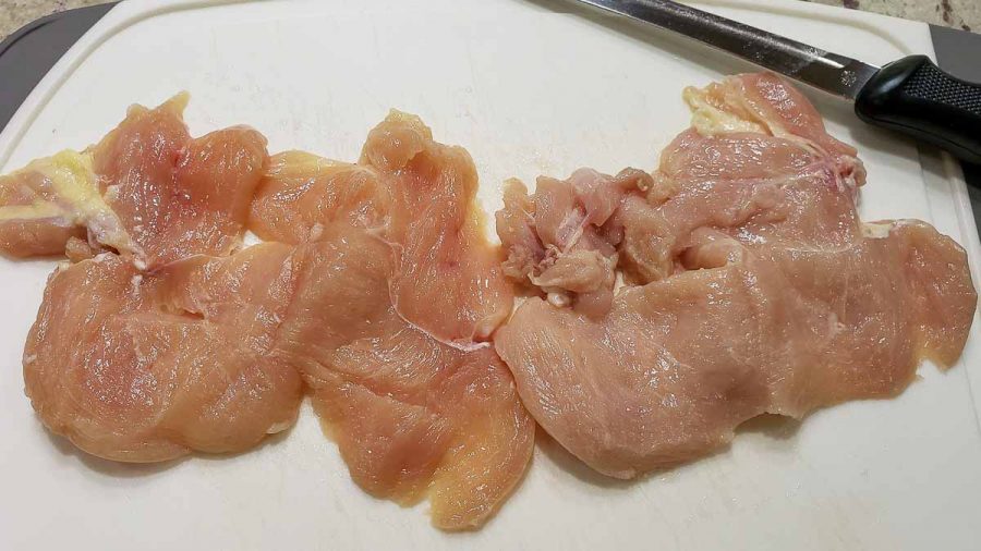 2 boneless chicken filets butterflied on a cutting board