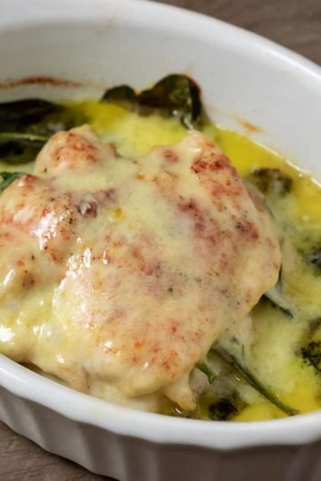 Top down view of White Cheddar and Spinach Stuffed Chicken in a baking dish
