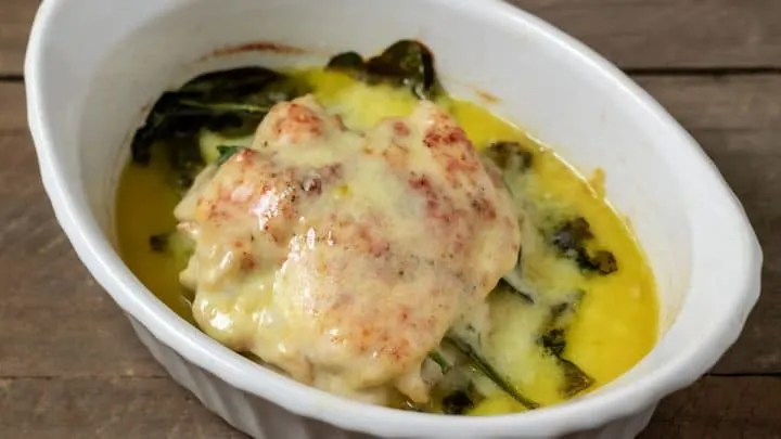 Top down view of White Cheddar and Spinach Stuffed Chicken in a baking dish
