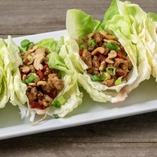 close up front view of 4 Low-carb Asian Chicken Lettuce Wraps on a platter