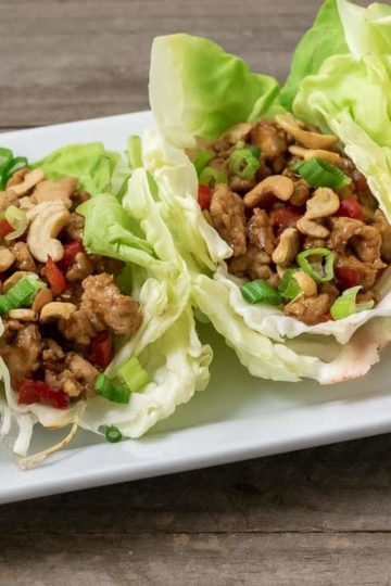 close up front view of 4 Low-carb Asian Chicken Lettuce Wraps on a platter
