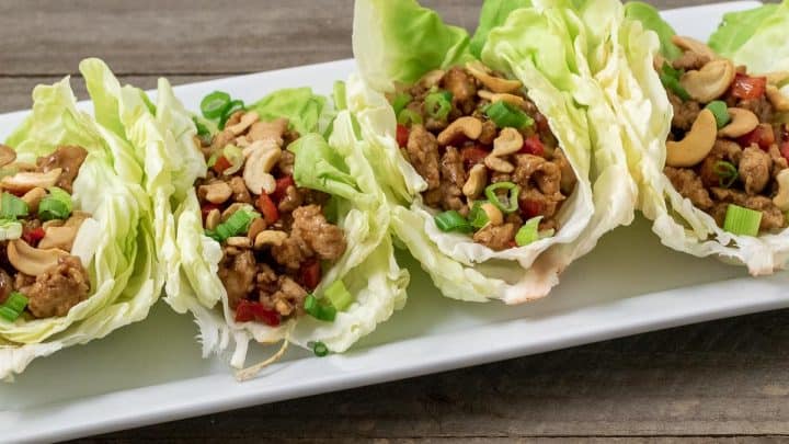 close up front view of 4 Low-carb Asian Chicken Lettuce Wraps on a platter
