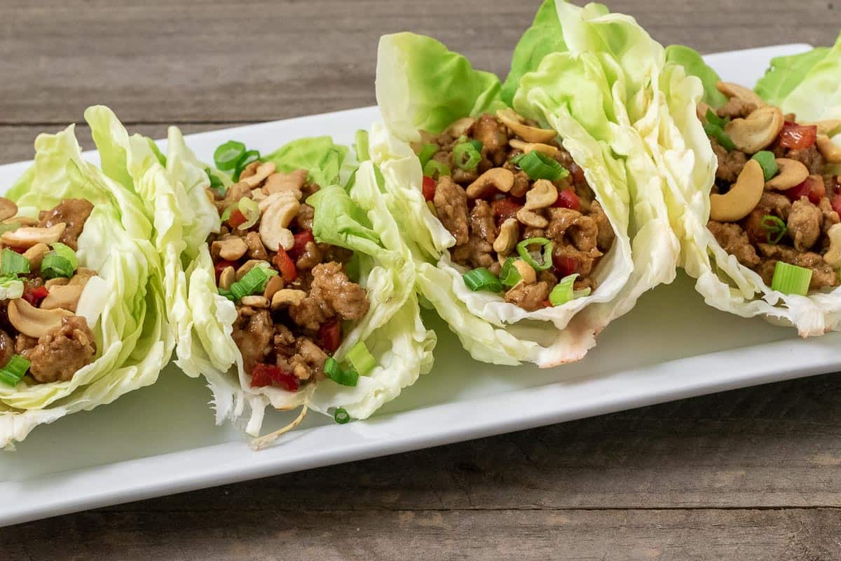 close up front view of 4 easy healthy Low Carb Chicken Lettuce Wraps on a platter.